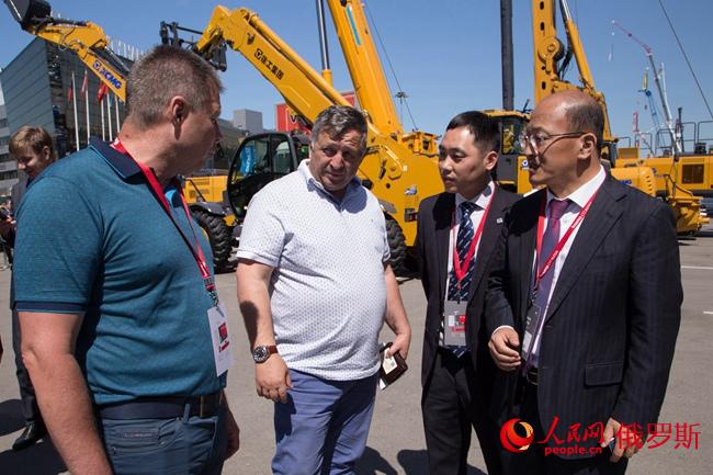 徐工機(jī)器副總裁、徐工團(tuán)體收支口公司總司理劉建森向俄經(jīng)銷商先容設(shè)備（右一）（實習(xí)生 陳效坤 攝）